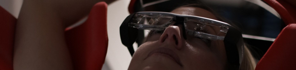 Patiënt met de VR-bril waarin het ademhalingssignaal van de patiënt door het oranje staafje wordt weergegeven. I